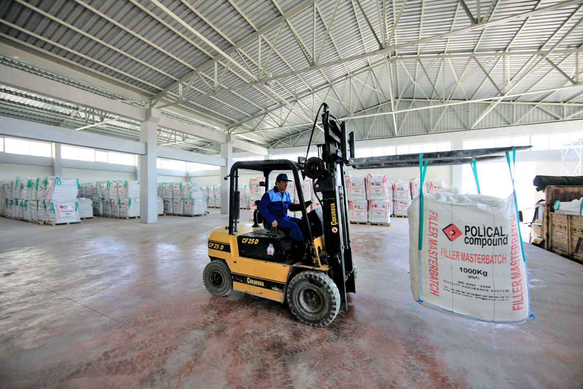 Forklift operator moving big bag in warehouse